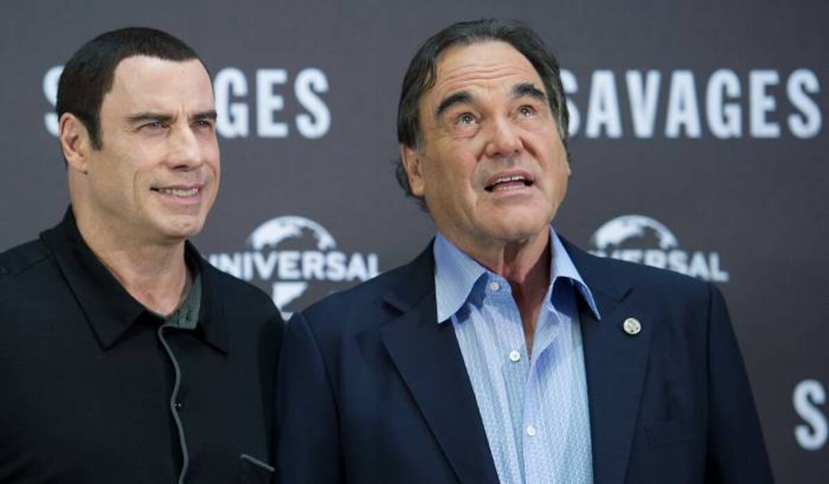 John Travolta (izquierda) y Oliver Stone. AFP HANNIBAL HANSCHKE