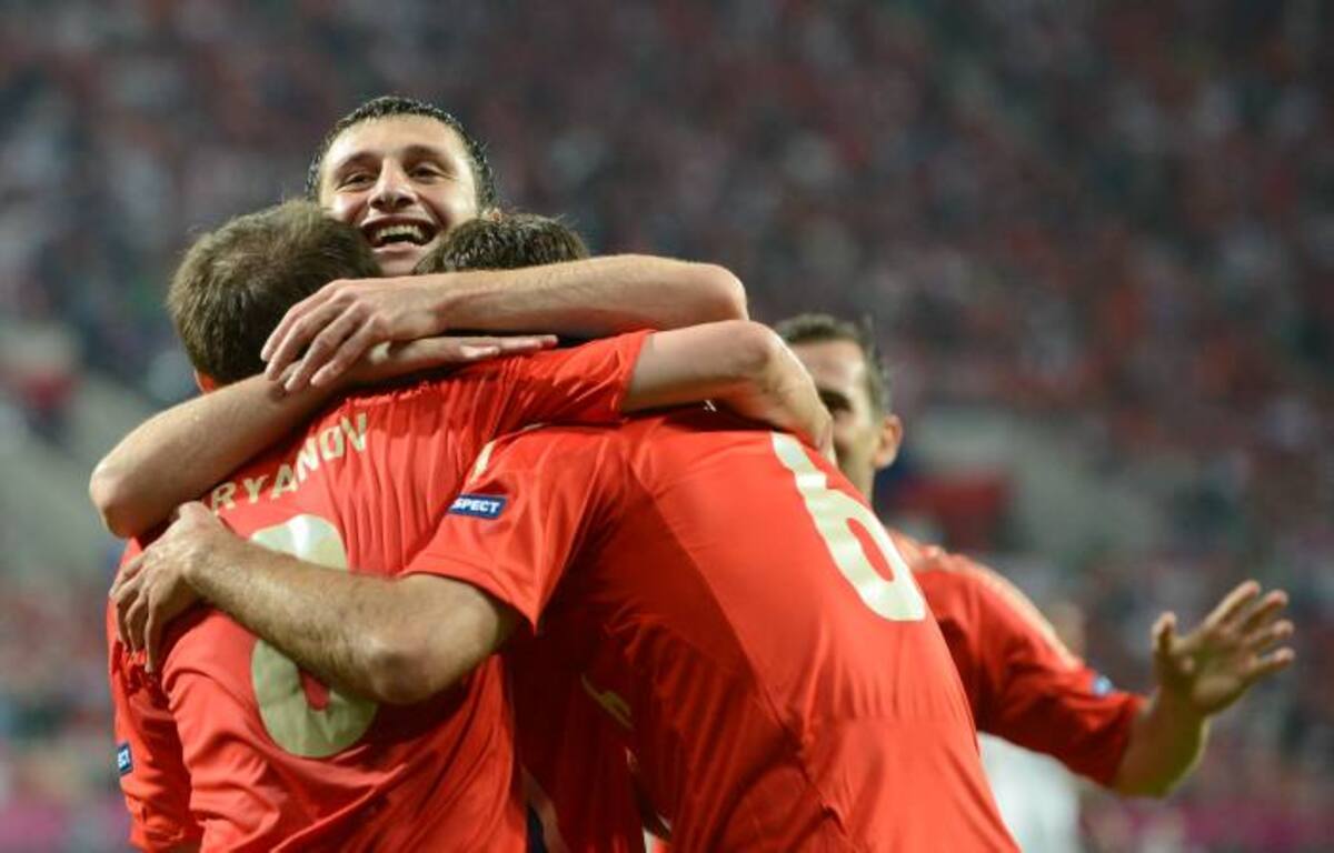 Alan Dzagoev es felicitado por sus compañeros al anotar el gol de Rusia, que finalmente empató 1-1 ante Polonia. AFP