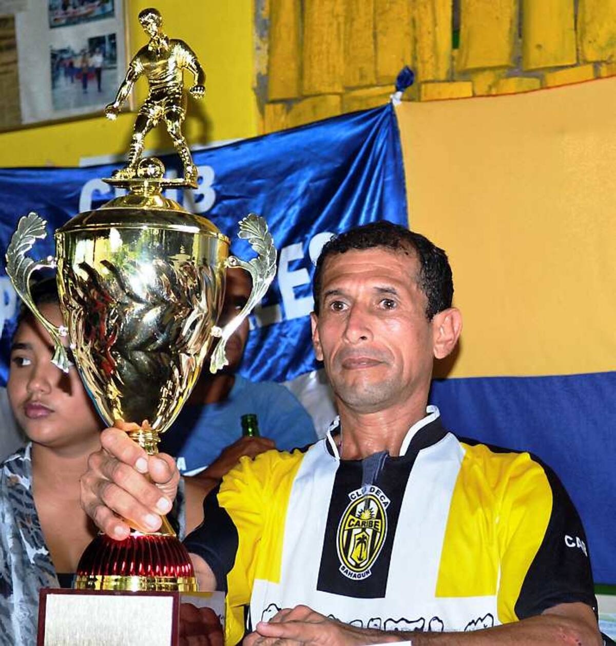 Raúl López, capitán del Club Caribe recibe el trofeo de campeón de fútbol.