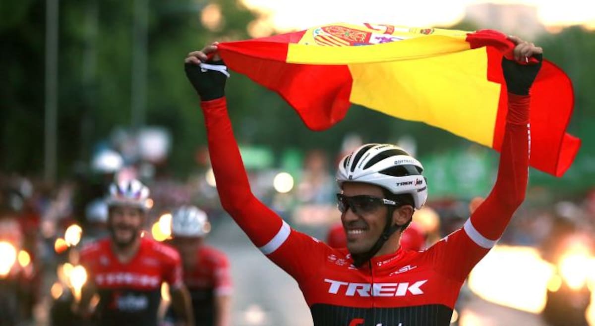 Alberto Contador pasó por la meta de la última etapa de la Vuelta a España en la Plaza de la Cibeles de Madrid con la bandera de España y aclamado por el público. EFE