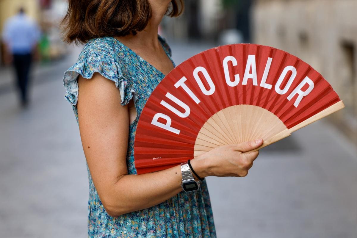 Una mujer combate el calor con un abanico. //EFE