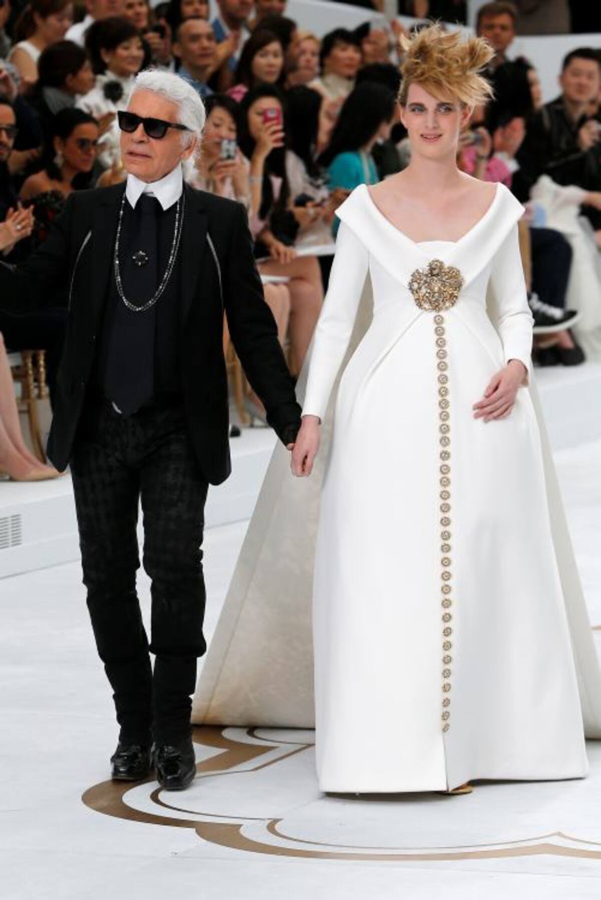 El diseñador, Karl Lagerfeld con una modelo, al finalizar el desfile. FOTOS AFP