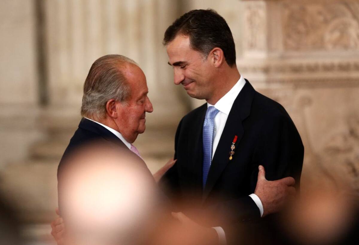 El rey Juan Carlos abraza a su hijo, el nuevo rey Felipe VI durante el acto en el cual Juan Carlos firmó la ley que dio luz verde a la abdicación.