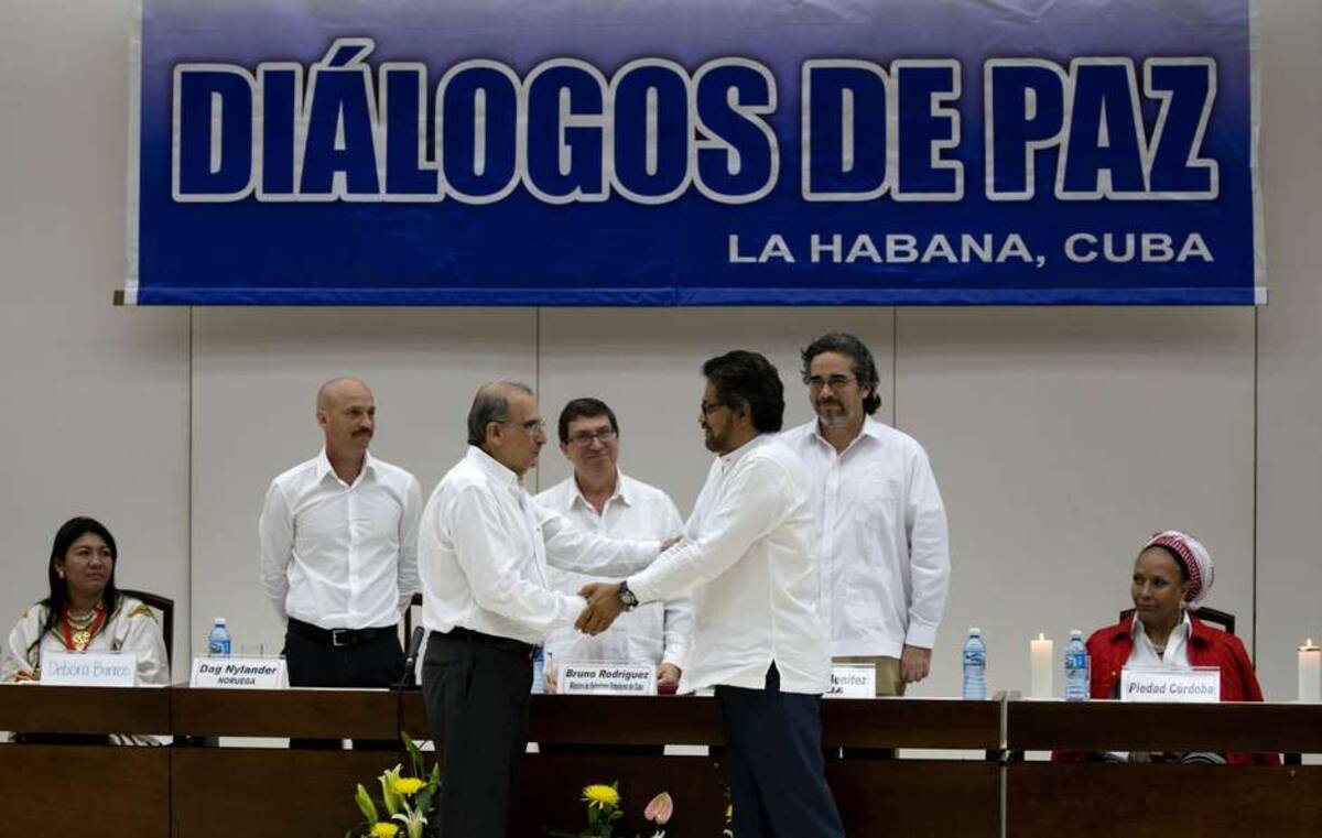 El jefe negociador del gobierno colombiano, Humberto de la Calle, le da la mano a Iván Márquez, jefe negociador de las FARC. AP