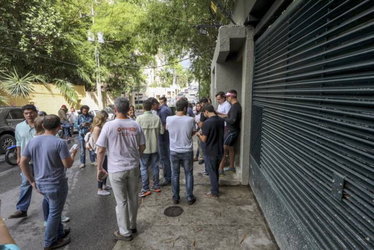 Familiares, miltantes del partido Voluntad Popular, junto a miembros del Servicio Bolivariano de Inteligencia Nacional, permanecen en la entrada de la casa en Caracas del opositor venezolano Leopoldo López. EFE
