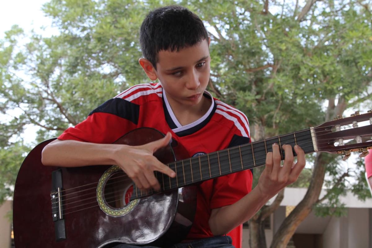 Brayan toca la guitarra con el alma.