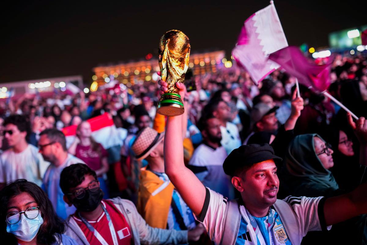La gente en la zona de aficionados ve en una pantalla gigante la ceremonia inaugural de la Copa del Mundo, en Doha, Qatar. //AP