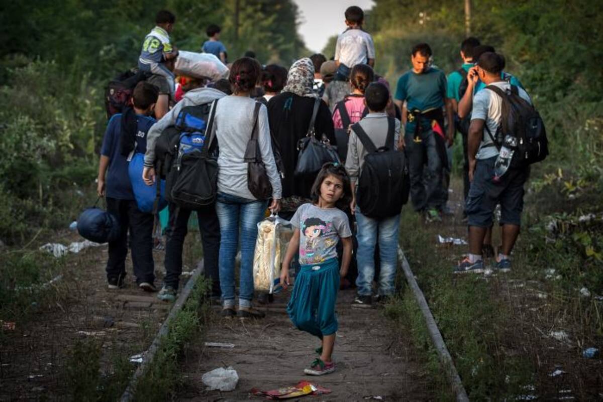 Inmigrantes atraviesan la frontera por las vías férreas. AFP