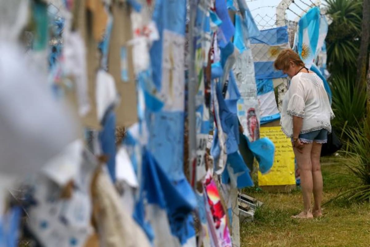 Personas visitan los alrededores de la base para brindar apoyo a familiares de las víctimas. EFE
