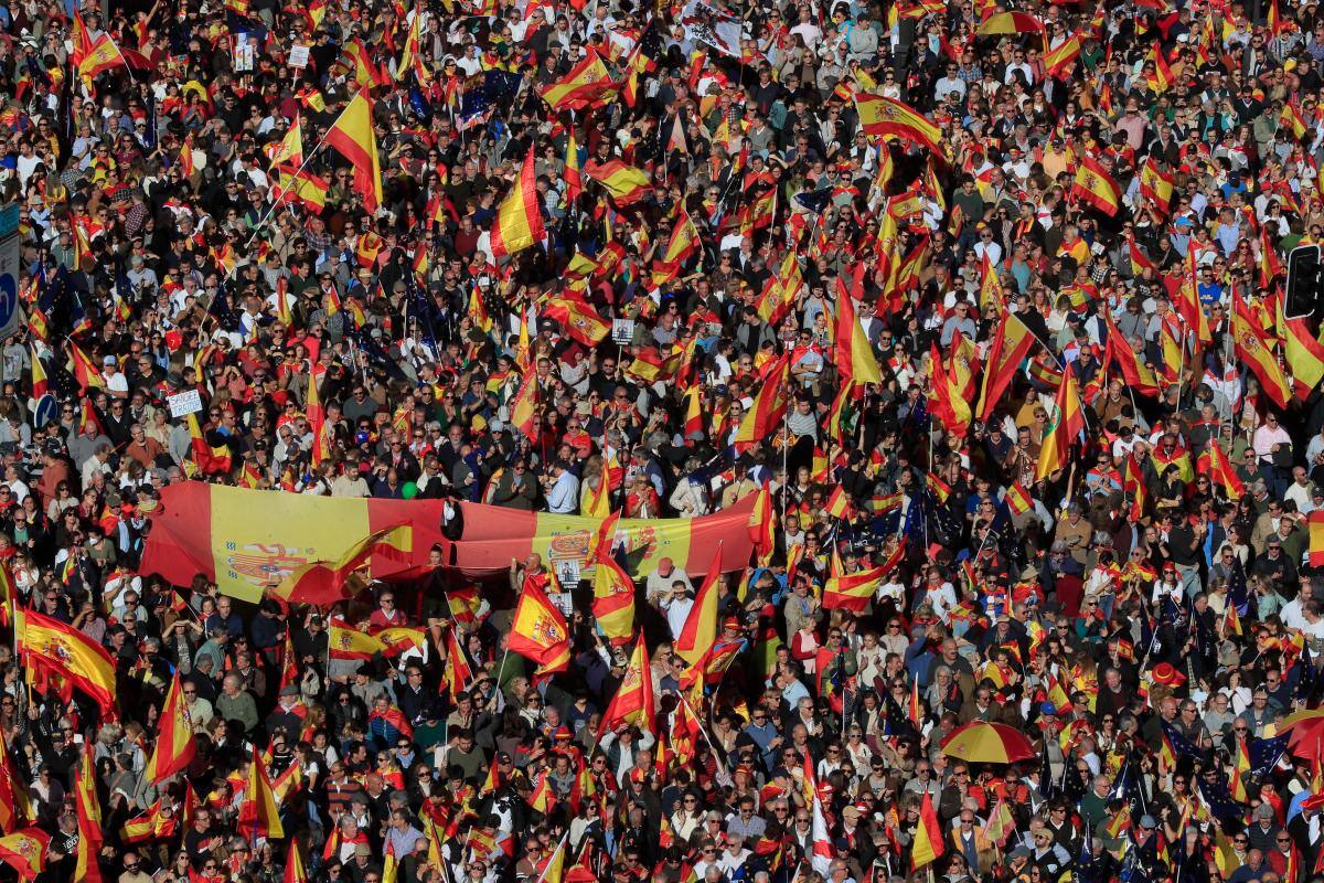 Miles de personas acuden con banderas a la manifestación convocada este sábado en Madrid por un centenar de organizaciones de la sociedad civil contra la amnistía. //EFE