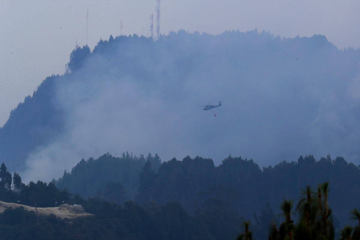 Un helicóptero combate hoy un incendio forestal en el cerro El Cable, en Bogotá (Colombia). //EFE/ Carlos Ortega