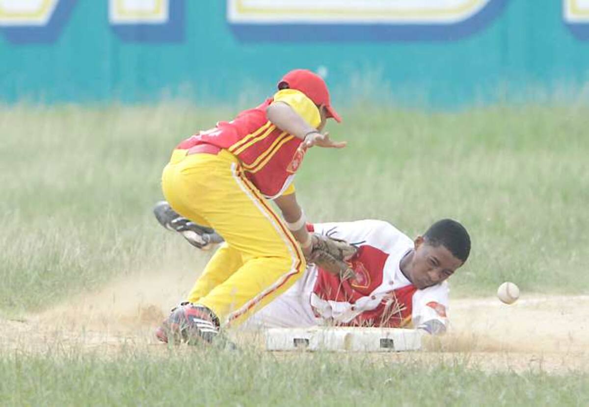 Luis Figueroa, de Comfenalco, no logra poner en out a Jhon de Aguas, de Villanueva (13), durant l juego del sábado en el estadio Rafael Naar de Turbaco. Julio Castaño-El Universal