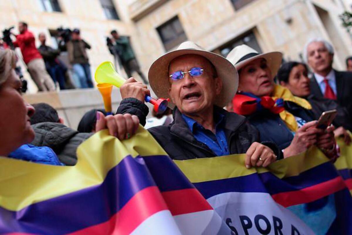 Los manifestantes exhiben pancartas, ondean banderas y carteles en contra y a favor de Uribe. // Colprensa