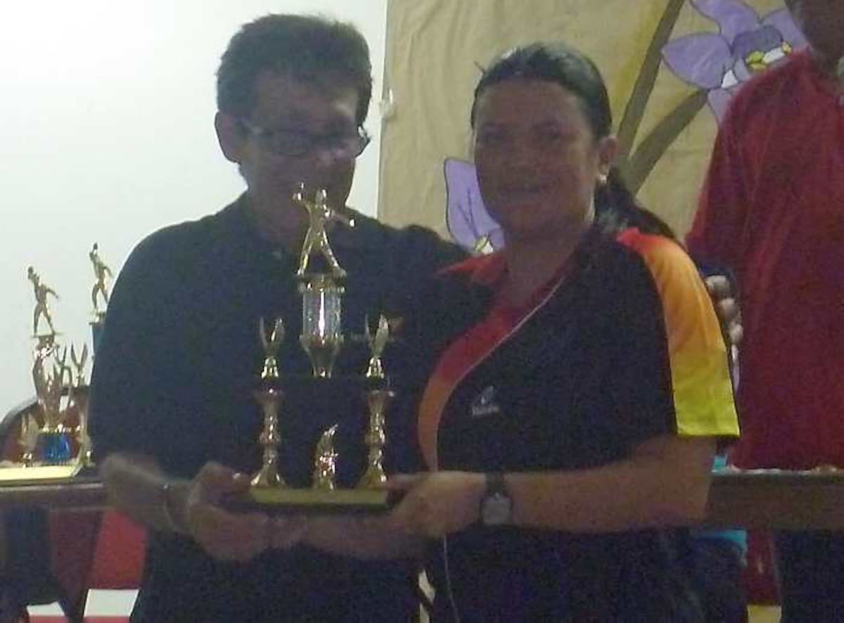 La tenista momentos en que recibe la distinción de campeona en tenis en evento deportivo.