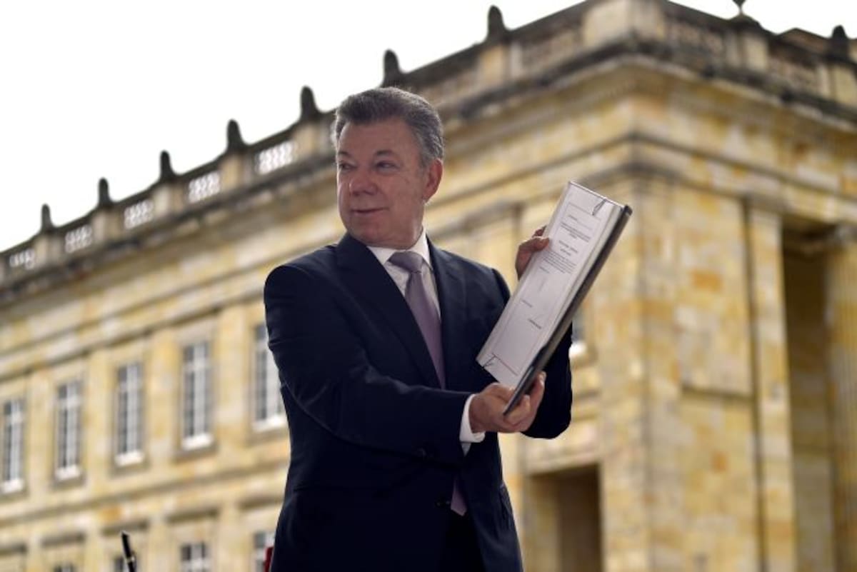 Tras su sanción, el Presidente Juan Manuel Santos muestra la ley estatutaria por la cual se adopta el estatuto de la oposición política y algunos derechos a las organizaciones políticas independientes. Cortesía Presidencia