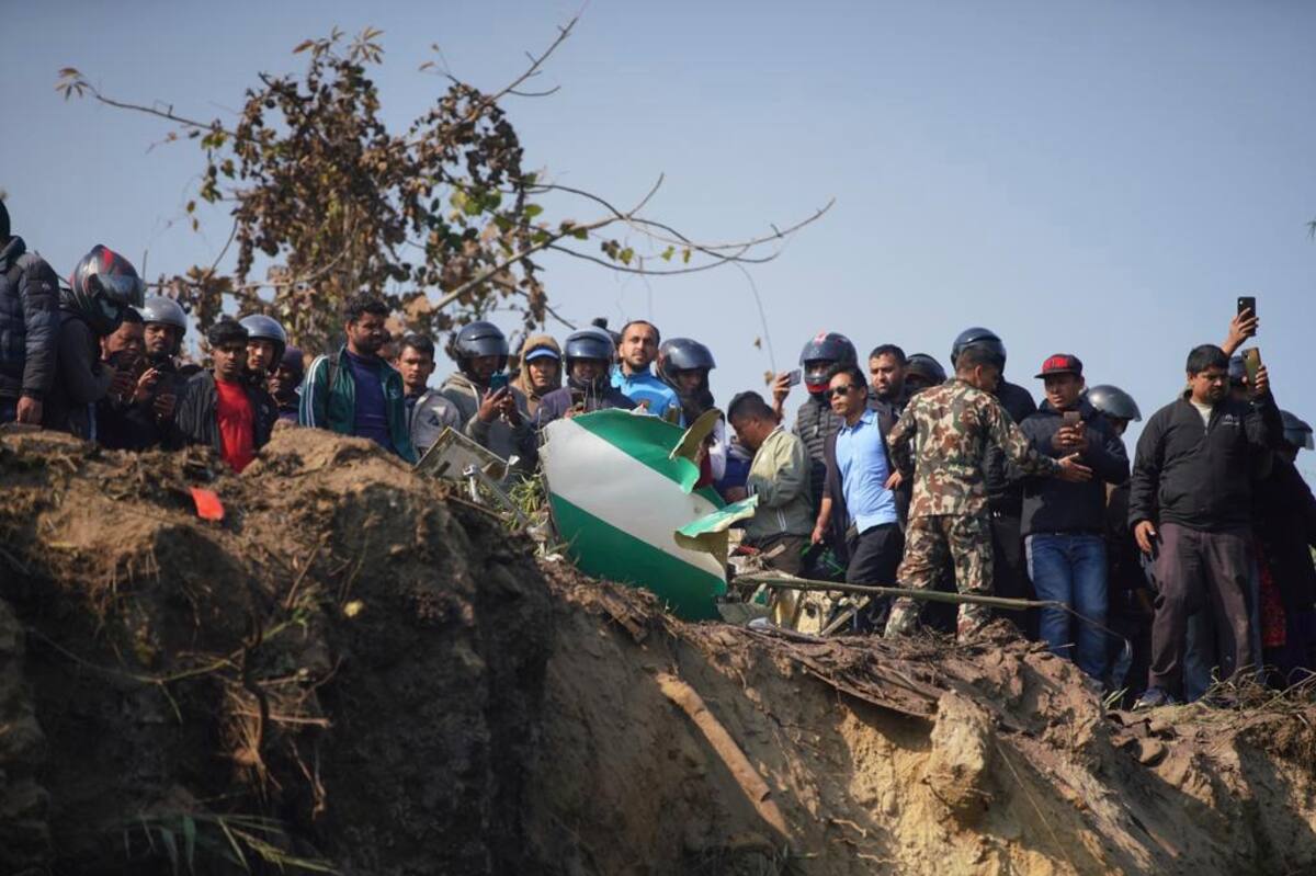 Los lugareños observan los restos de un avión de pasajeros en Pokhara. // Foto: AP.