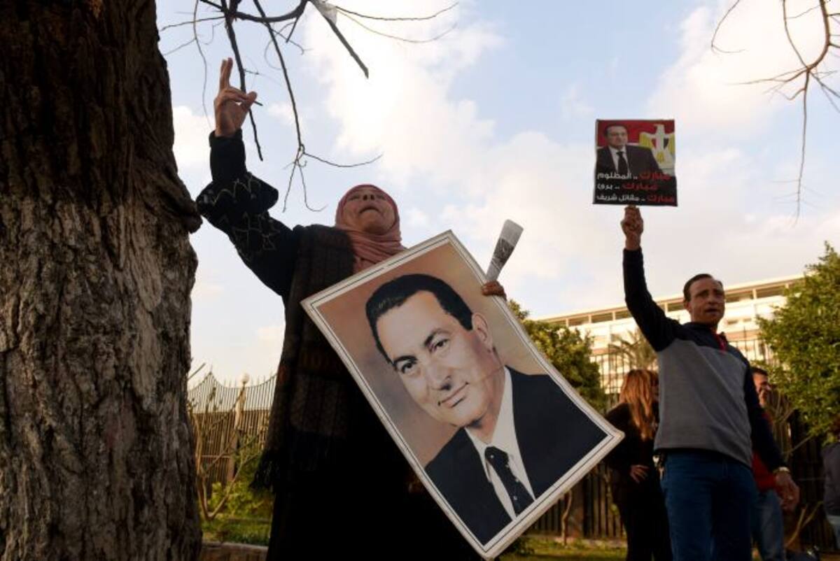 Los partidarios del ex presidente egipcio Hosni Mubarak, cantan consignas en su apoyo cuando se reúnen fuera del hospital militar Maadi en El Cairo el 2 de marzo de 2017 para darle la bienvenida a su regreso de una audiencia en la corte. / AFP / AFP