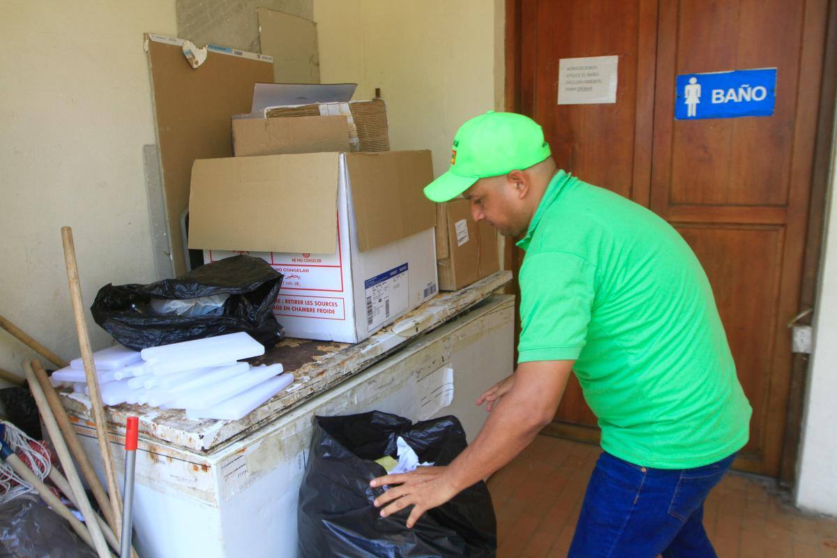 Funcionario recoge basura acumulada en los baños. //Julio Castaño.