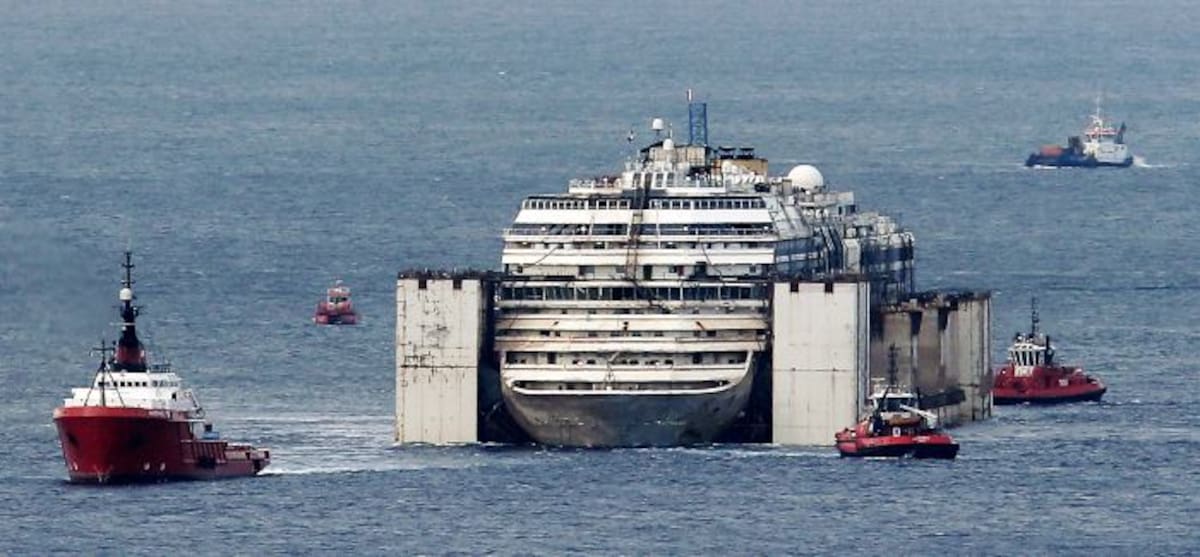 El crucero es arrastrado por varios remolcadores. AFP MARCO BERTORELLO