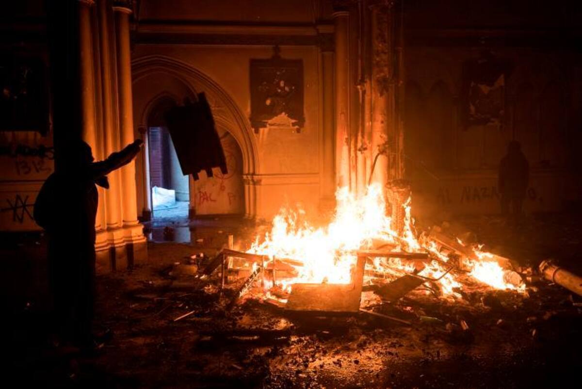 Un grupo de manifestantes entró a la iglesia de San Francisco de Borja mientras una barricada ardía en los alrededores de la Plaza Italia de Santiago (Chile), rebautizada popularmente como “Plaza Dignidad”. EFE/Alberto Valdés