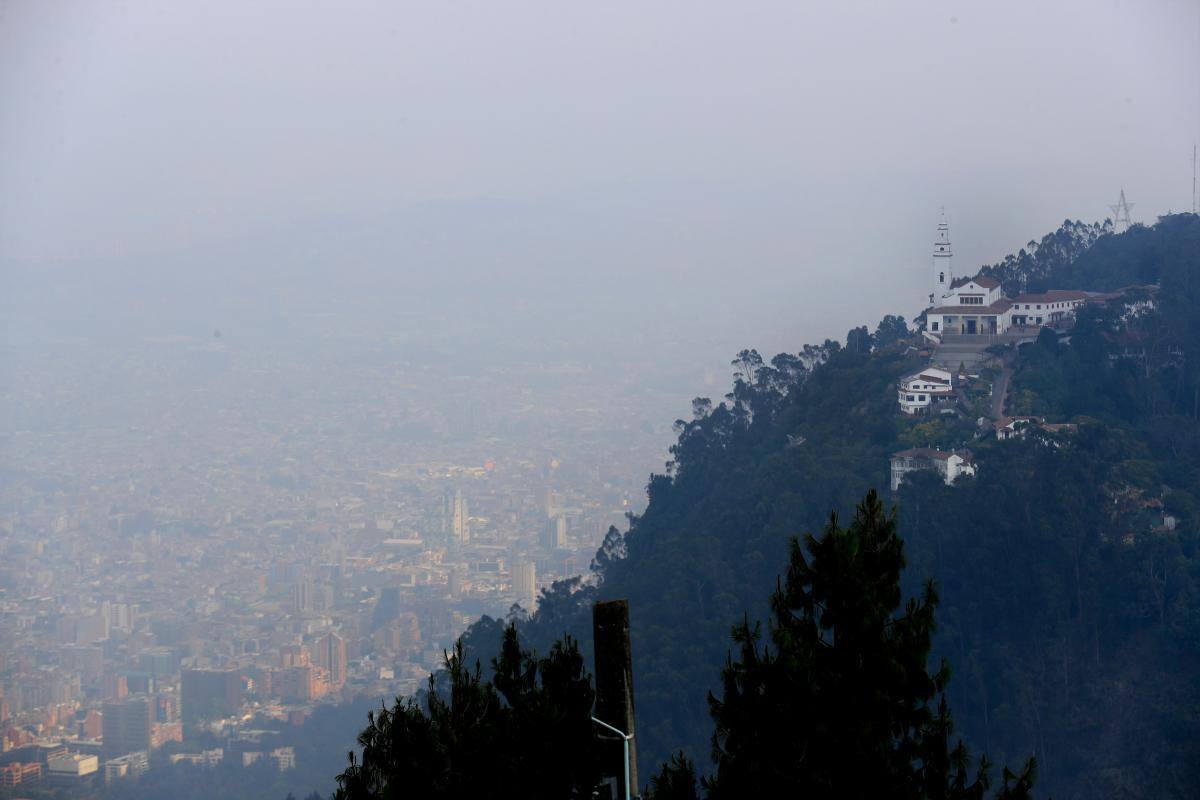 Vista hoy del cerro de Monserrate (d) bajo una capa de humo producida por los incendios de los cerros orientales de Bogotá (Colombia). //EFE/ Carlos Ortega