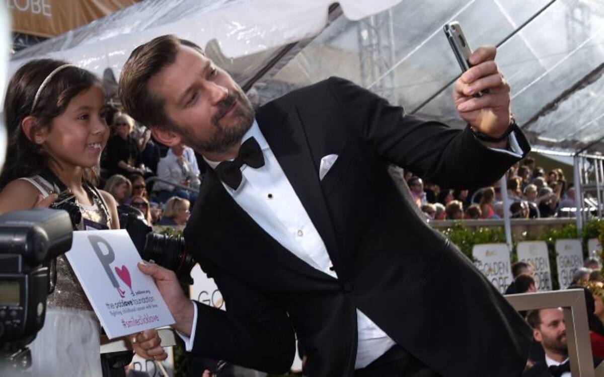 Nikolaj Coster se toma una fotografía con una fan. AP