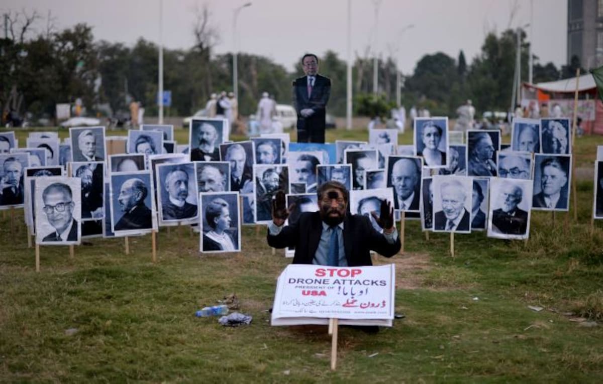 Un líder pakistaní grita consignas delante de los retratos de los ganadores del Premio Nobel y una fotografía de Ban Ki-moon durante una protesta contra los drones de Estados Unidos. AFP AAMIR QURESHI