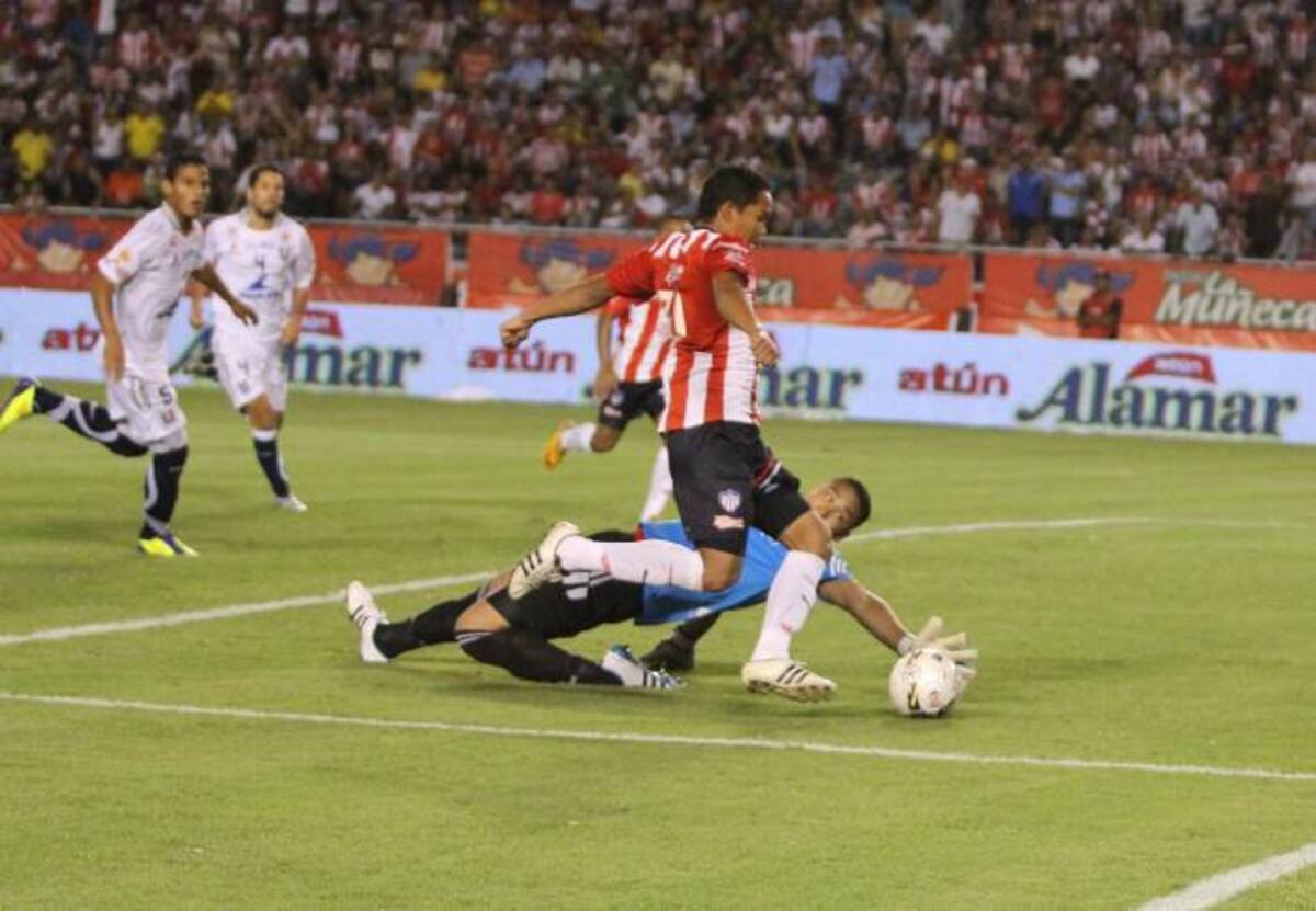 Carlos Bacca, autor de dos tantos en el partido de ida en Barranquilla, elude al arquero Luis Martínez y le puso el pase a Vladimir Hernández para el gol del empate 2-2 ante Once Caldas. Jorge Payares-Qhubo Barranquilla