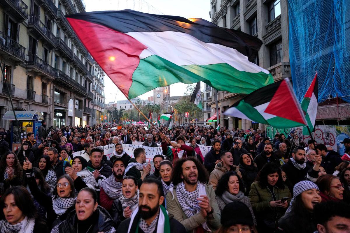 Decenas de personas, ondeando banderas palestinas, participan en una manifestación contra la guerra de Israel en Gaza este sábado, en Barcelona. EFE/ Alejandro García