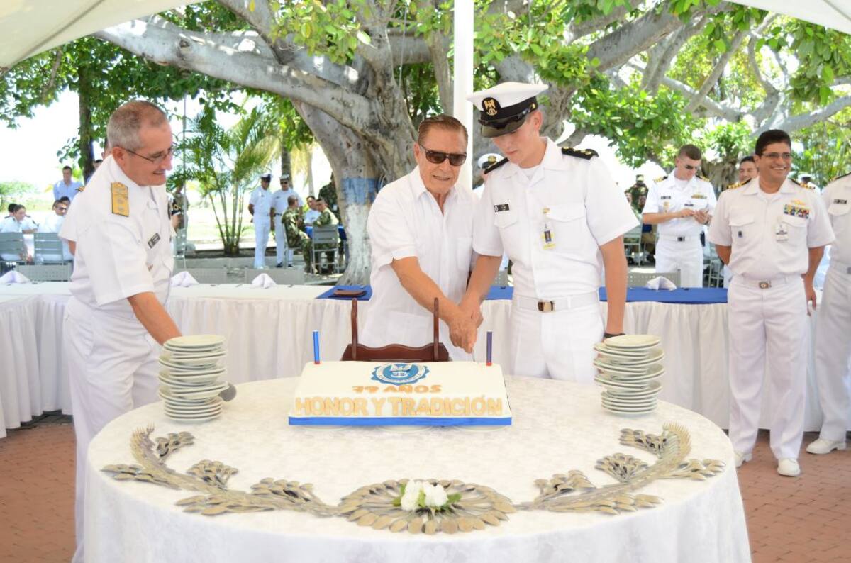 El almirante Guillermo Uribe fue el encargado de cortar el pudín por el aniversario de la Escuela. Lo acompaña el cadete Toro, de primer año.