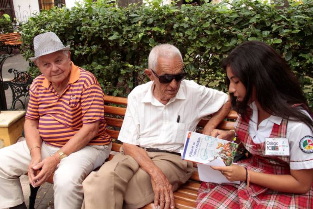 Adultos mayores escucha atento a una estudiante en el Parque de Bolívar Zenia Valdelamar.