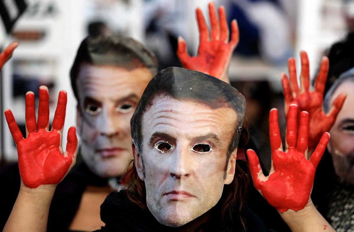 Decenas de personas participan en una manifestación en apoyo al pueblo palestino este sábado en Montpellier, Francia, portando máscaras del presidente francés Emmanuel Macron, y alzando las manos, que simulan estar ensangrentadas. EFE/ Guillaume Horcajuelo.