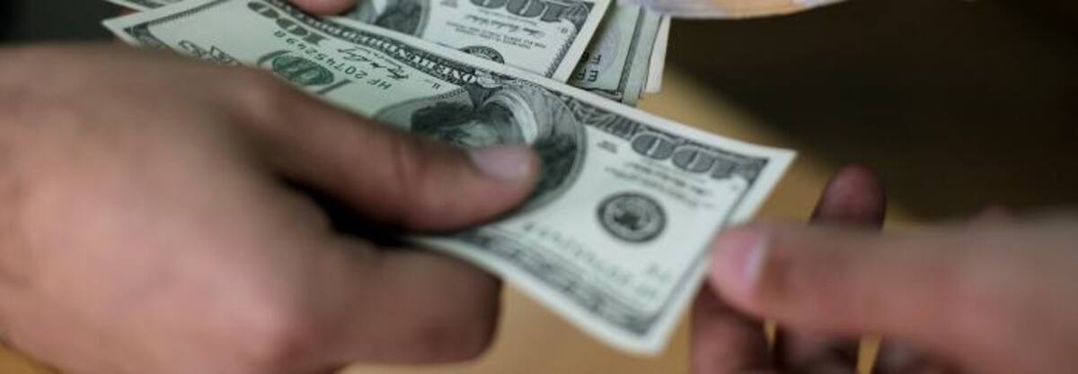 Dolares y bolivares. AFP