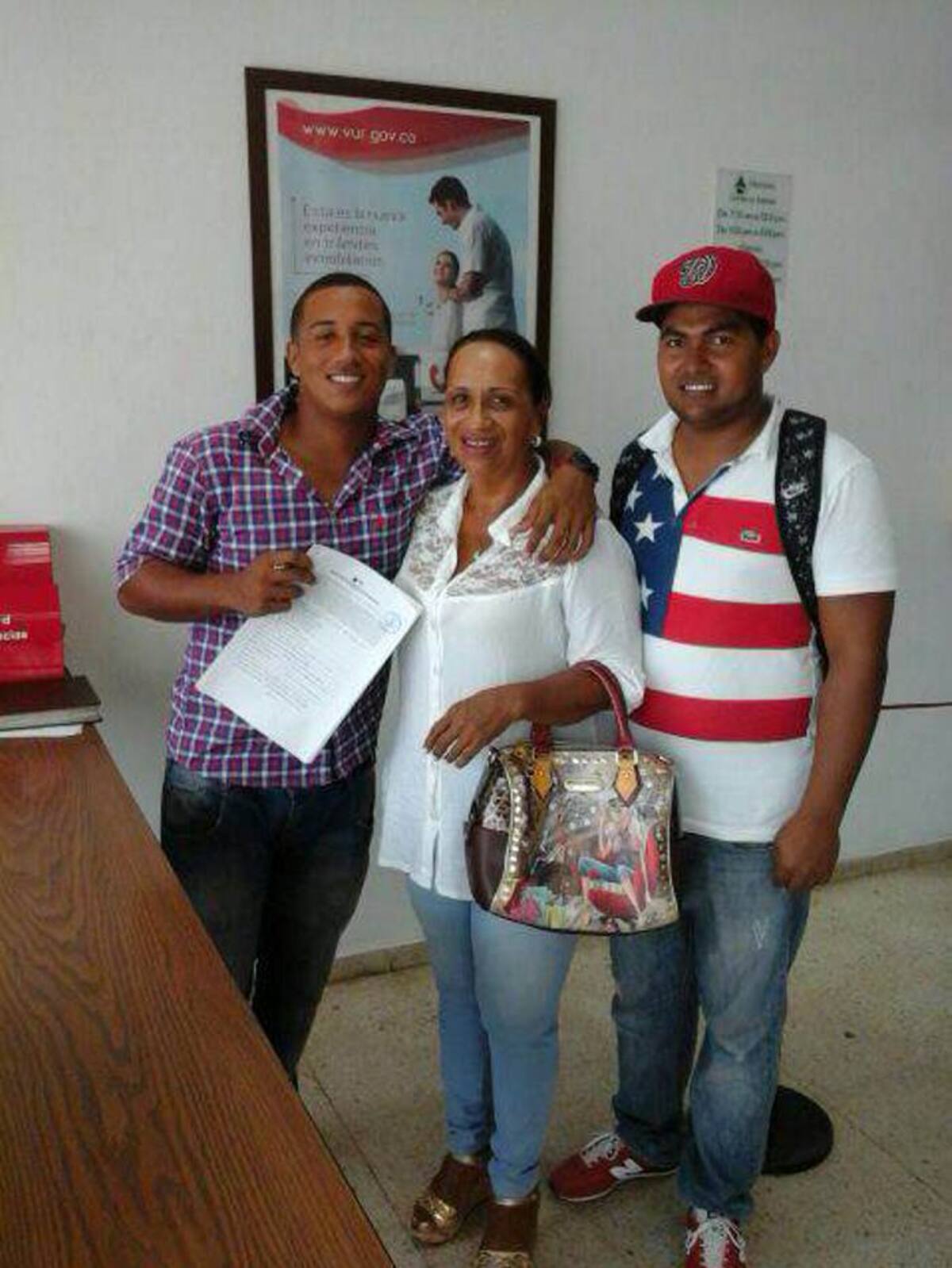 Roberto Medina y Eduardo Cabrera, scout de los Nacionales de Washington en el momento de la firma. Con ellos Sidara Salema, madre de Medina. Cortesía