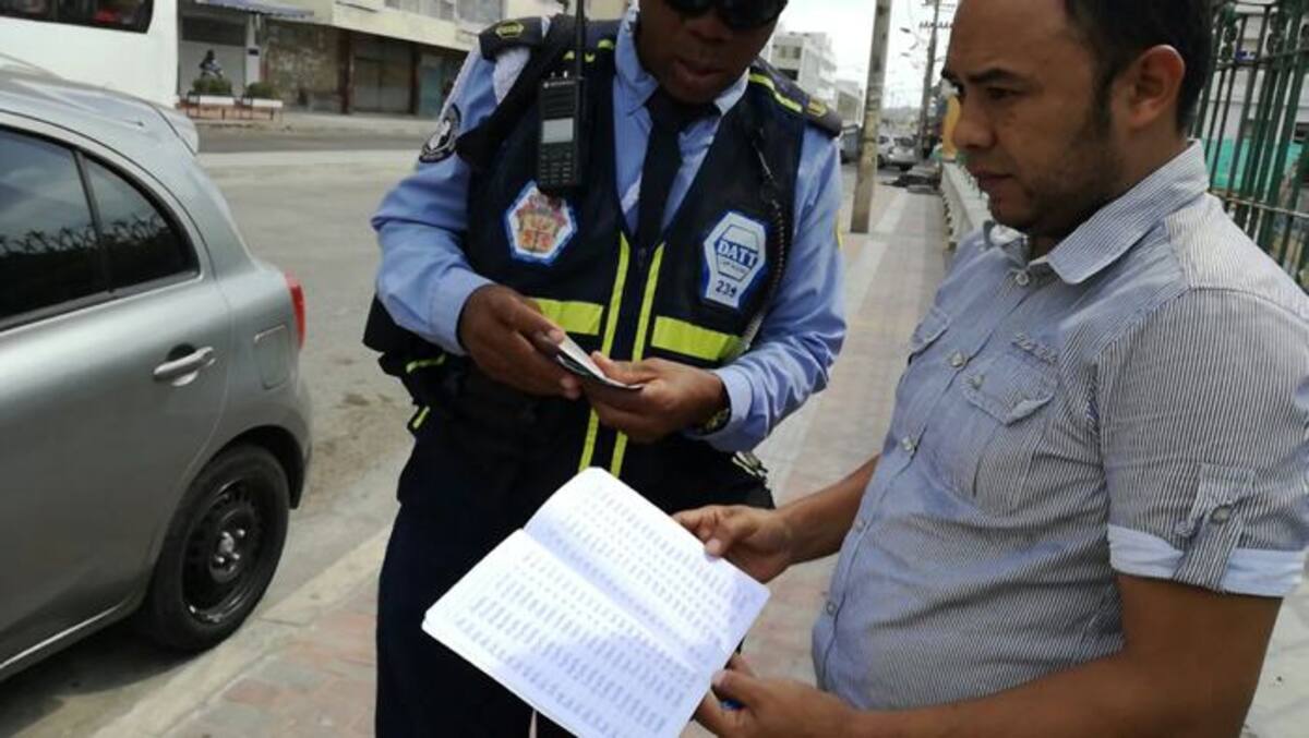 Conductor sancionado entrega sus planas al agente de tránsito. Cortesia.