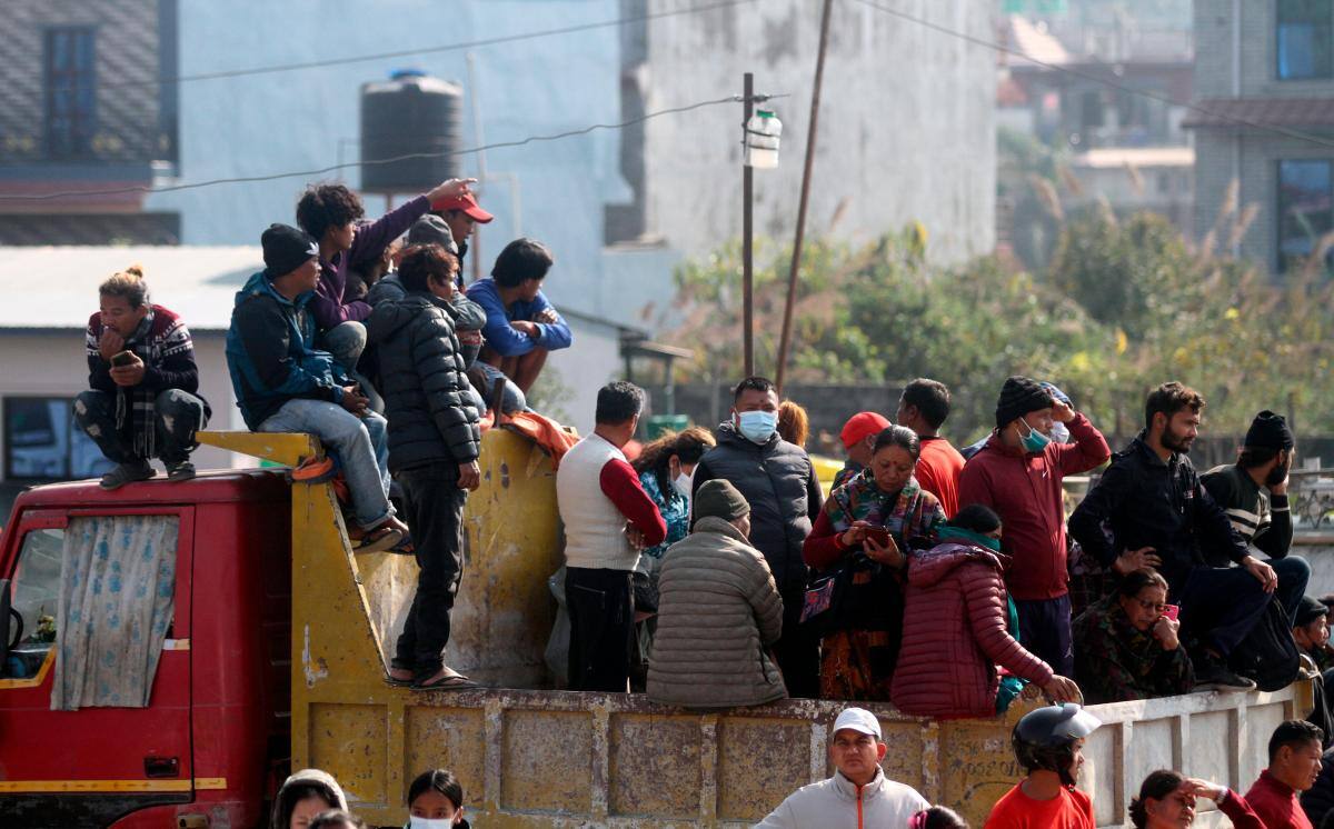 Los lugareños observan desde la distancia cómo continúan los trabajos de rescate en el lugar del accidente. // Foto: EFE.