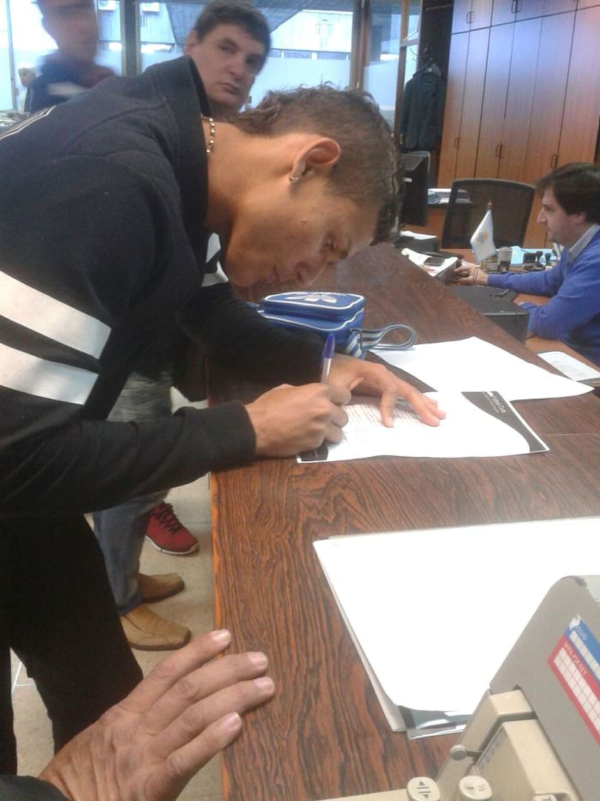 El momento en que Andrés estampa su firma que lo vincula como jugador de Danubio. CORTESÍA
