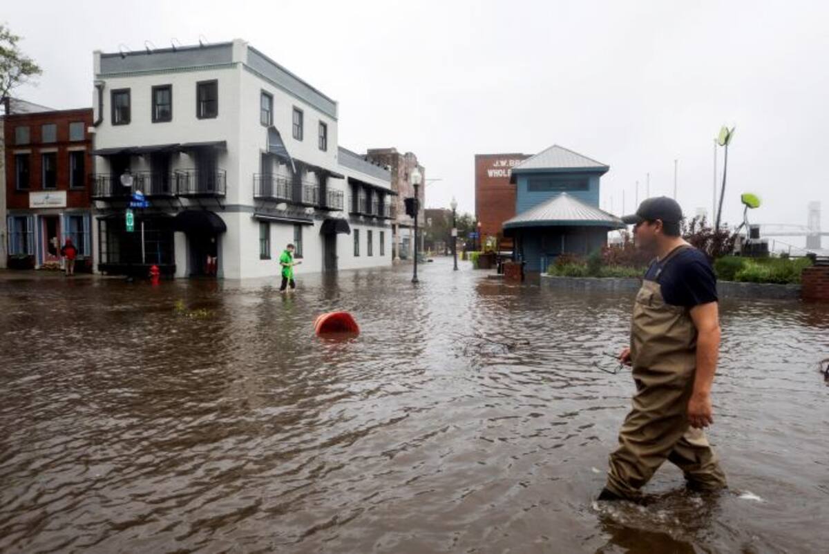 Varios vecinos caminan por una calle inundada tras el paso del huracán Florence, en Wilmington, Carolina del Norte, EE.UU. EFE