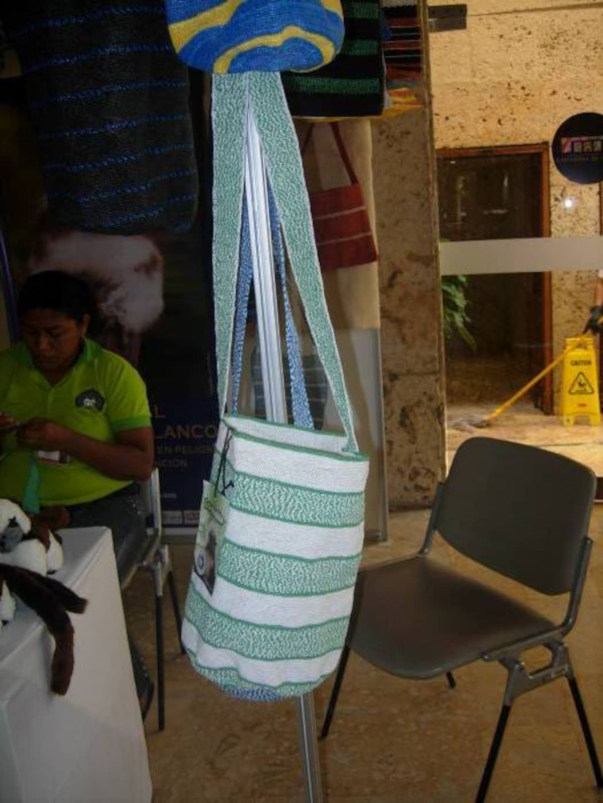Una de las mochilas elaboradas con bolsas menchas de color blanco y azul.