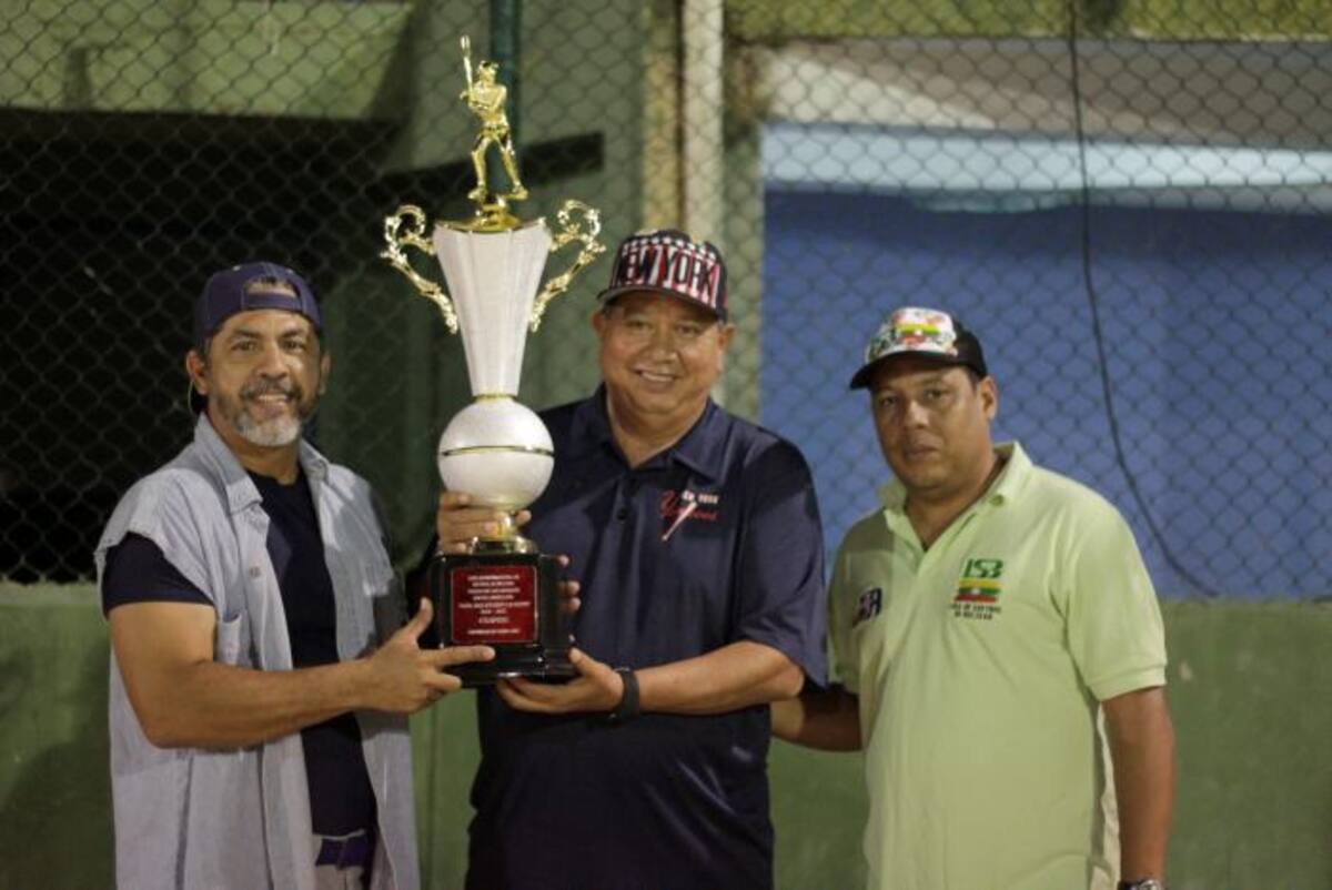 Hernando Villalobos, mánager de Élite (izquierda) recibe el trofeo de campeón de manos de Félix Devoz, tesorero de la Fedesóftbol y de Alberto Olivares, presidente de la Liga de Bolívar. NAYIB GAVIRIA EL UNIVERSAL