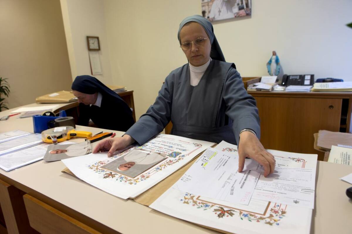 Una religiosa prepara los documentos papales. con los que se obtienen recursos para las limosnas