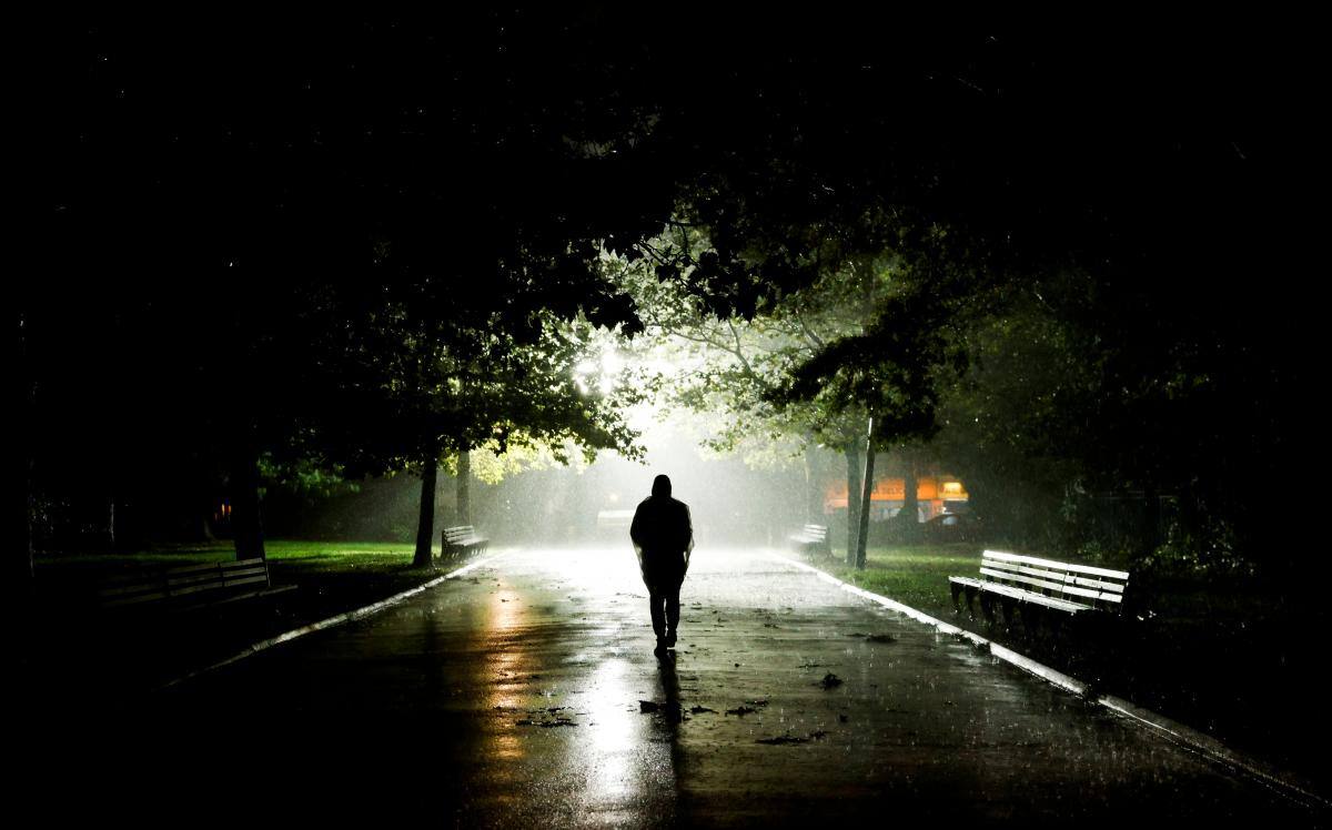 Un hombre camina por un parque durante una tormenta de lluvia cuando los restos del huracán Ida azotaron la zona en el distrito de Queens de Nueva York, Nueva York.