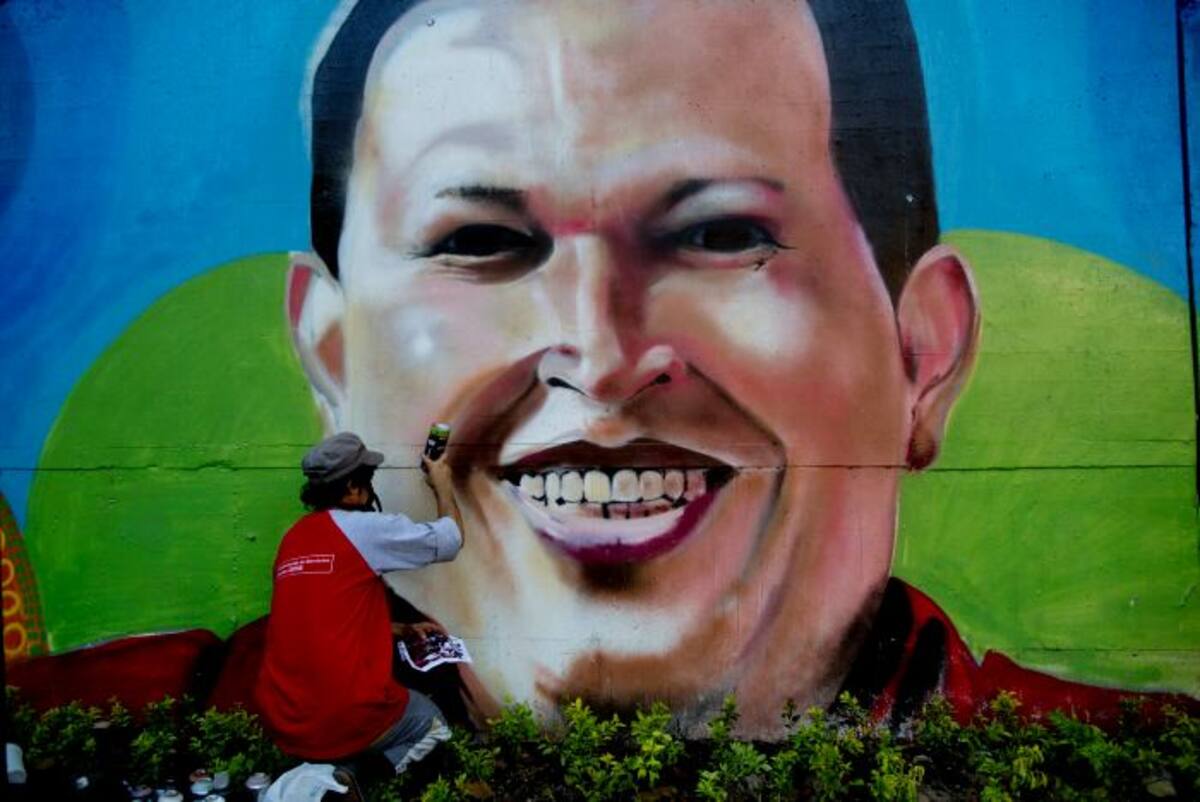 El artista Nicolay Shamanika restaura un mural del fallecido Hugo Chávez. AP Rodrigo Abd