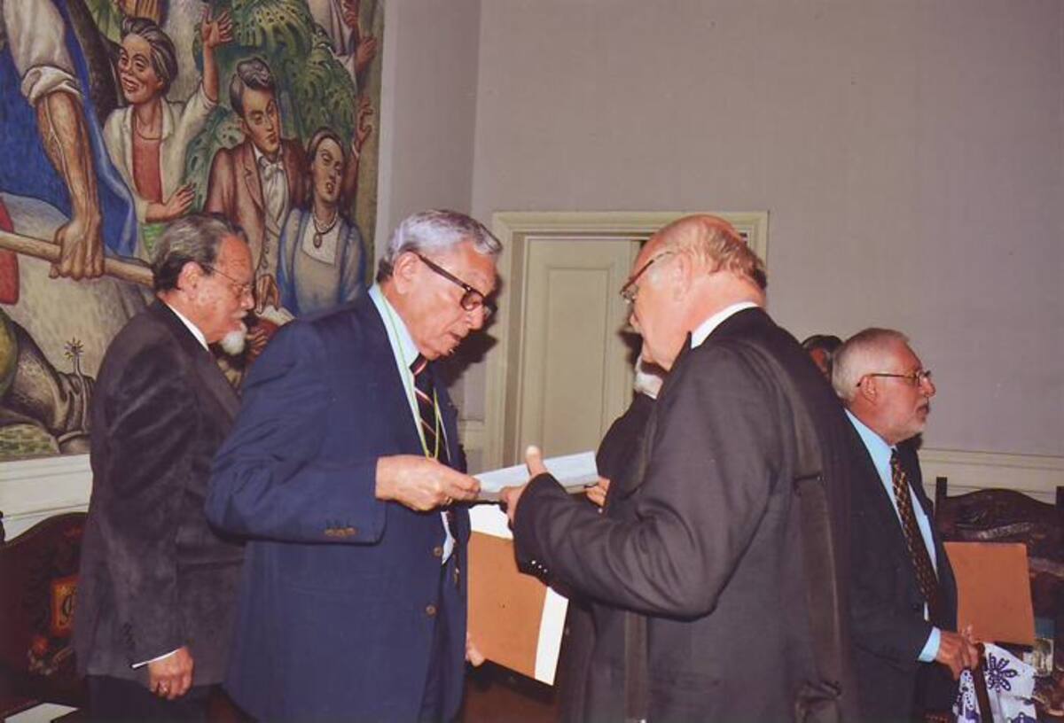 Carlos Villalba recibe el diploma de manos de Jaime Posada, presidente de la Academia Colombiana de la Lengua.
