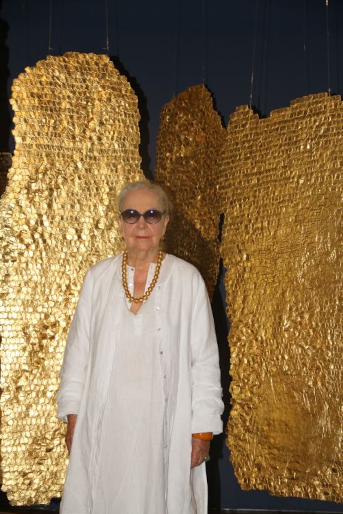 La artista Olga de Amaral junto a uno de sus espléndidos tapices dorados. Zenia Valdelamar