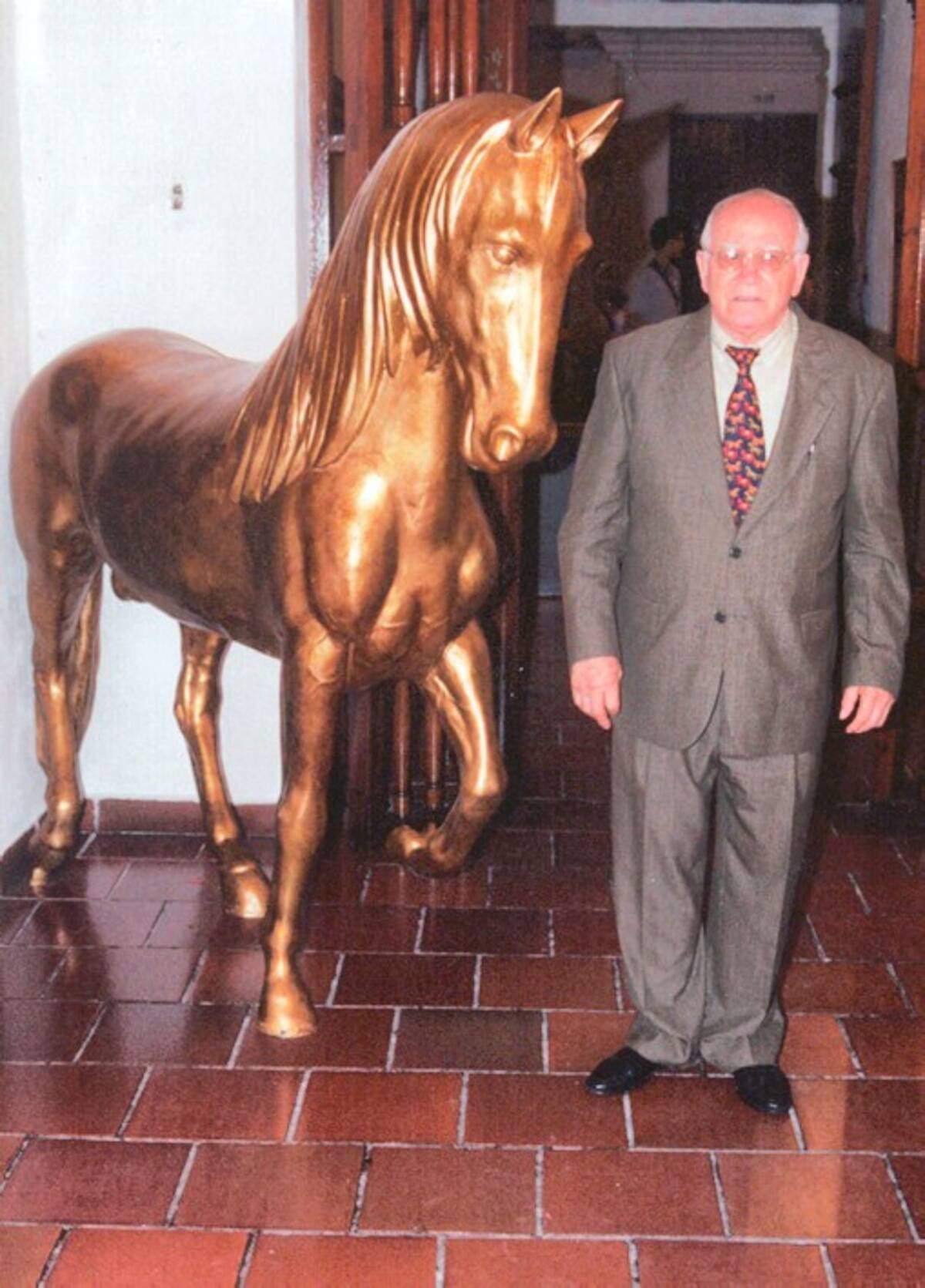 El artista junto a uno de sus caballos esculpidos.