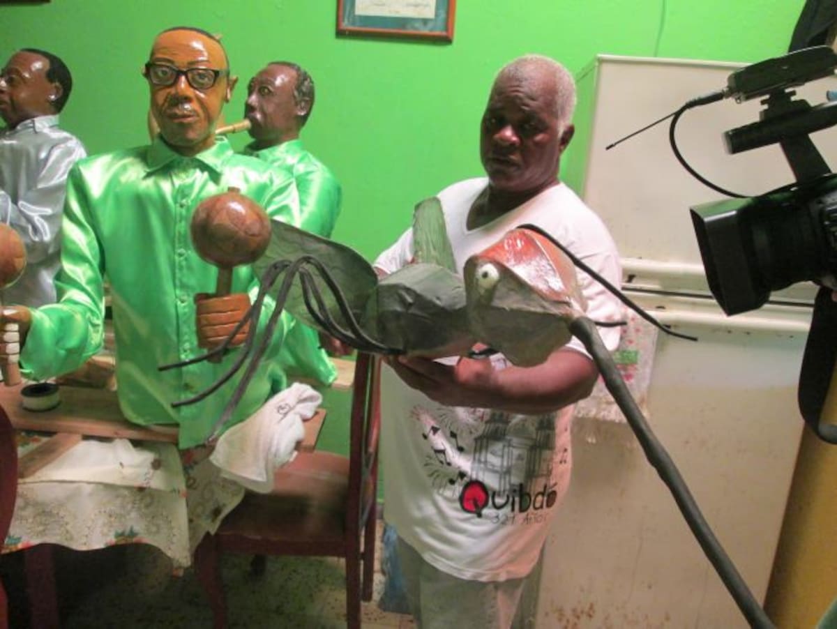 El profesor Jorge Murillo López, fabricante de carrozas. En sus manos, el mosquito portador de las enfermedades en el Chocó. Al fondo, la efigie del compositor Jairo Varela.