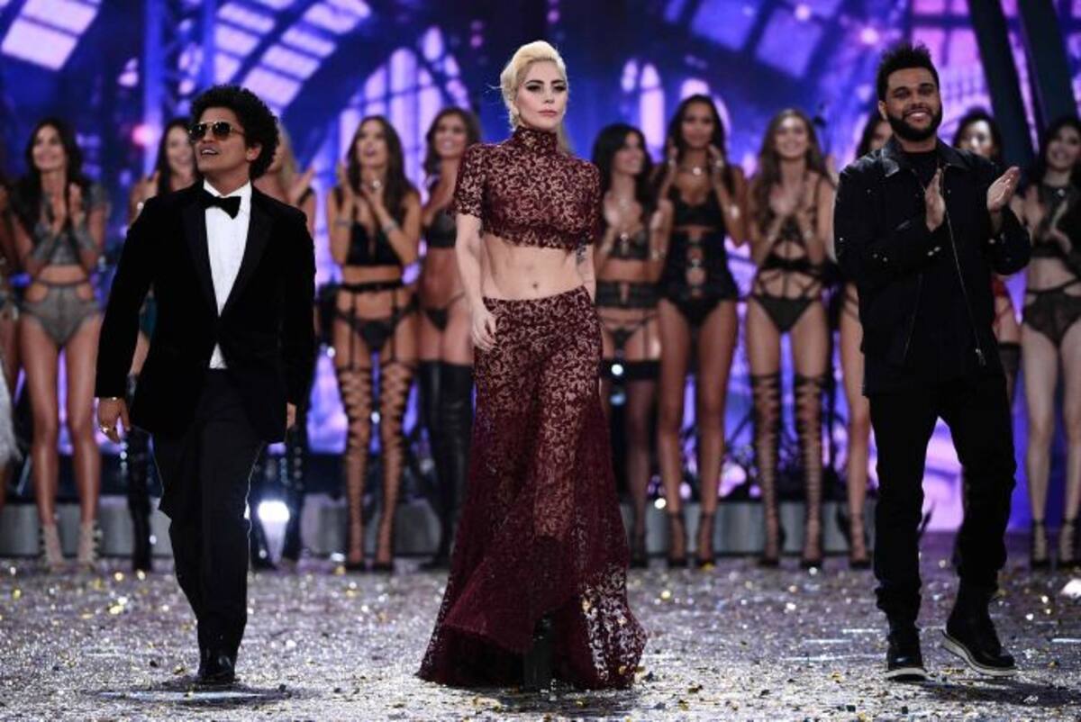 Los tres cantantes invitados juntos en el escenario. AFP