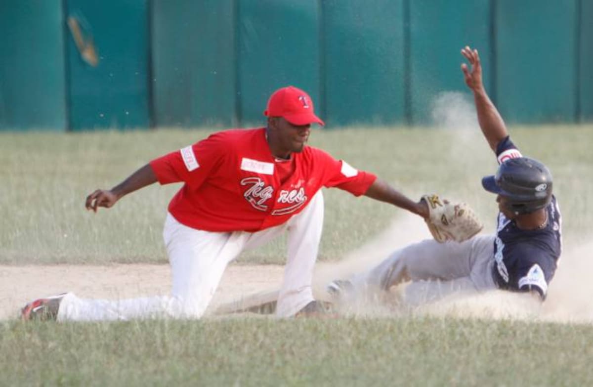 El campocorto Ronald Ramírez, de Tigres, no puede poner out al corredor Díover Ávila, de Leones, en una acción del juego realizado ayer en el estadio Rafael Naar de Turbaco. Julio Castaño-El Universal