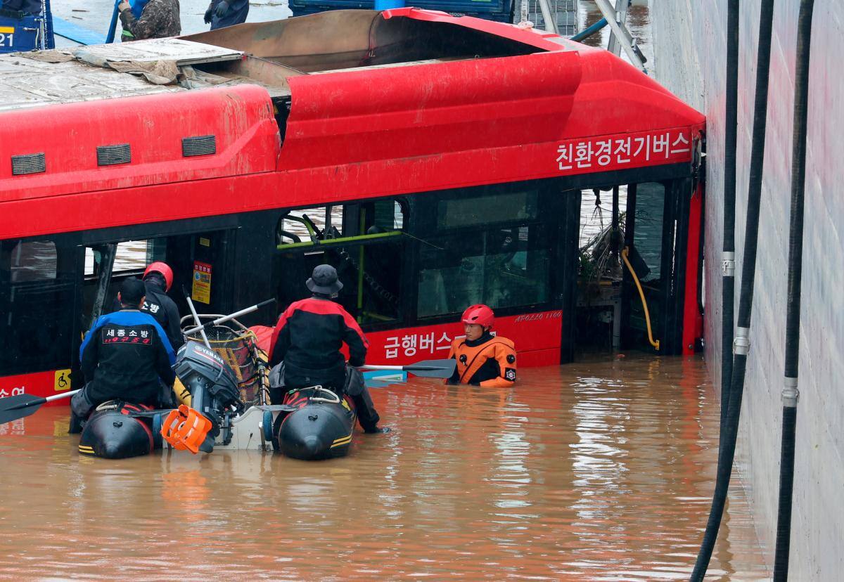 Un autobús sale de un túnel subterráneo inundado después de que el agua de la inundación sumergiera a 15 vehículos en la ciudad central de Osong, Corea del Sur. //EFE
